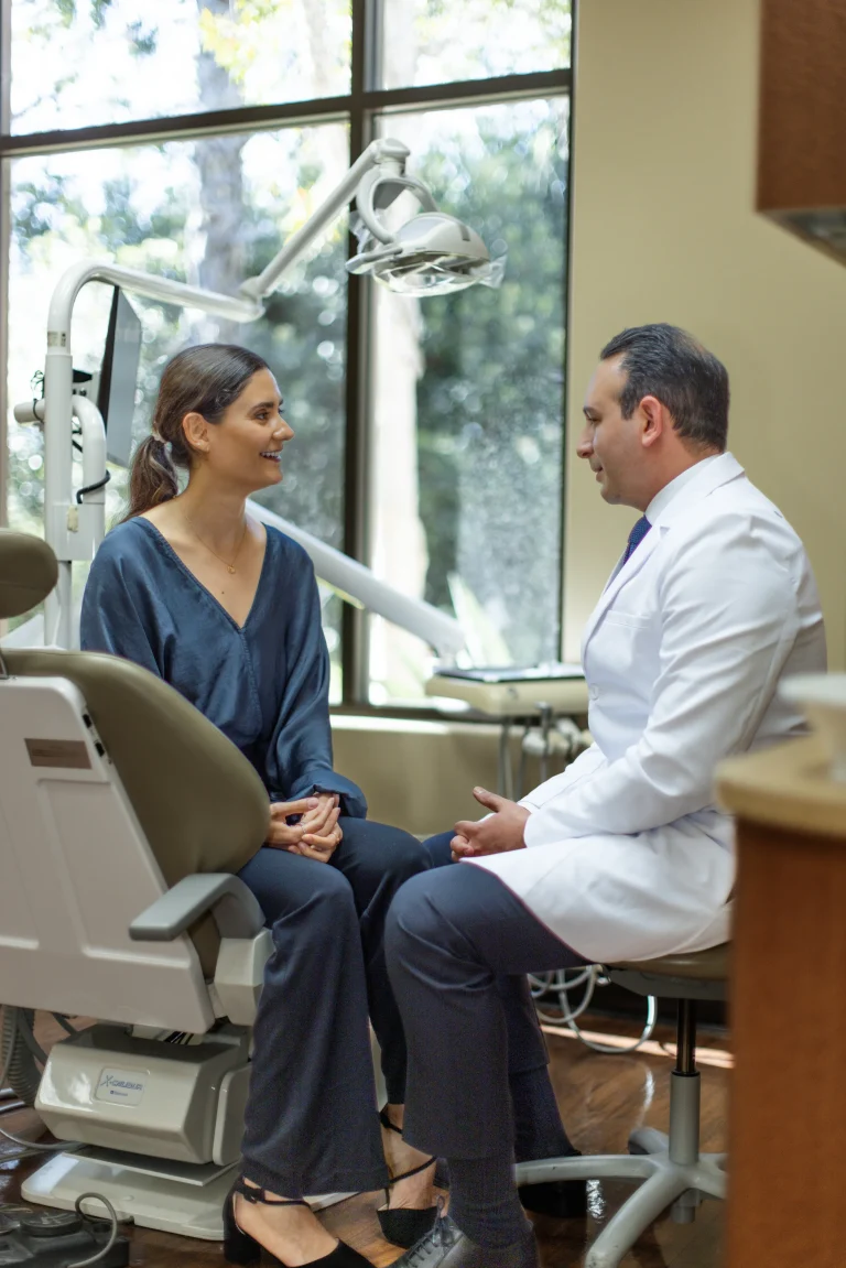 Dr. Ben and a patient seated facing each other beside the dental chair