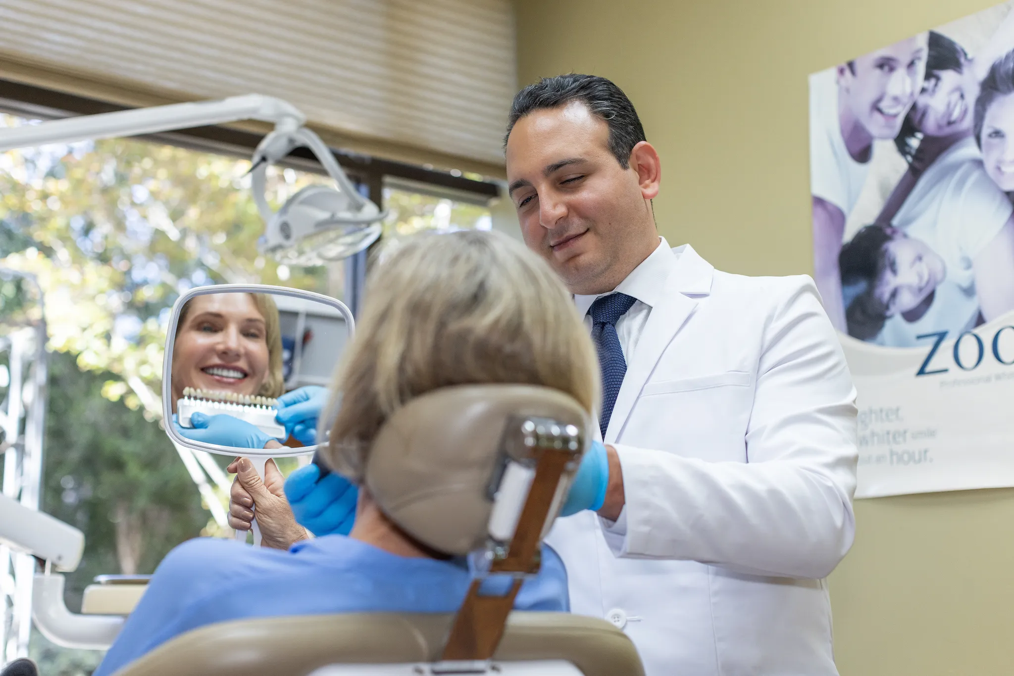 A patient seeing the result in the hand mirror